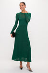 Model in a classic, high-end Green Shimmer Knit Cammie Maxi Dress, showcasing an effortless, fun look with a sleek fit, colorful earrings, and metallic heels.