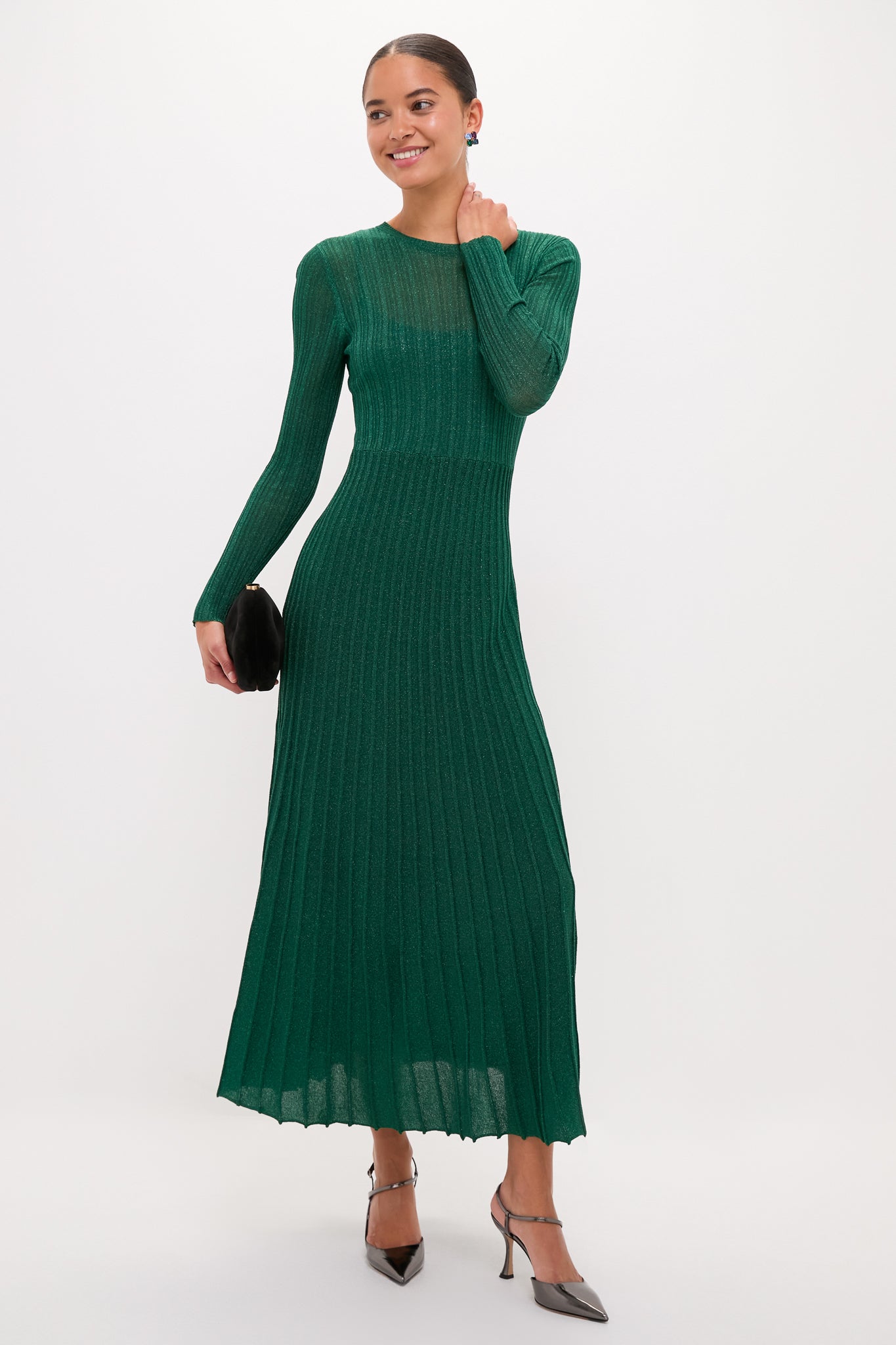 Model in a classic, high-end Green Shimmer Knit Cammie Maxi Dress, showcasing an effortless, fun look with a sleek fit, colorful earrings, and metallic heels.