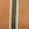 A vertical green stripe bordered by white runs down the center of a tan or light brown surface, creating a striking accent.