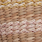 Close-up of a woven textile featuring rows of beige, pink, and tan fibers in a horizontal striped pattern, highlighting intricate texture.