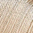 Close-up of beige knitted fabric showcasing a textured, repeating pattern of vertical ridges and cozy stitches.