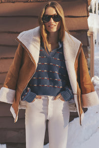 Person in snowy setting wearing the Camel Fur Trim Suede Coat, a classic, effortless layer with plush trim, perfect for a fun, high-end winter look.