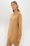A woman stands against a plain background wearing a Pomander Place long-sleeve tan sweater dress featuring a relaxed fit with ribbed cuffs and hem.