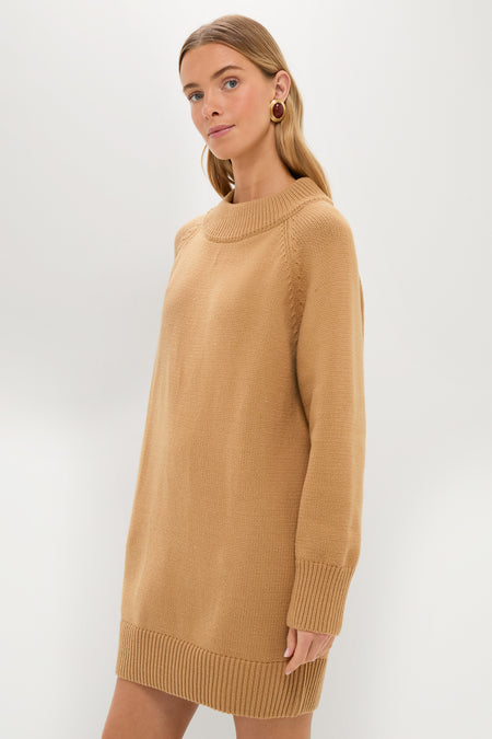A woman stands against a plain background wearing a Pomander Place long-sleeve tan sweater dress featuring a relaxed fit with ribbed cuffs and hem.