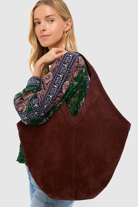 Model with classic Chocolate Soft M Hobo tote, showcasing effortless style with its versatile design and high-end Italian suede, paired with a bohemian blouse and jeans.
