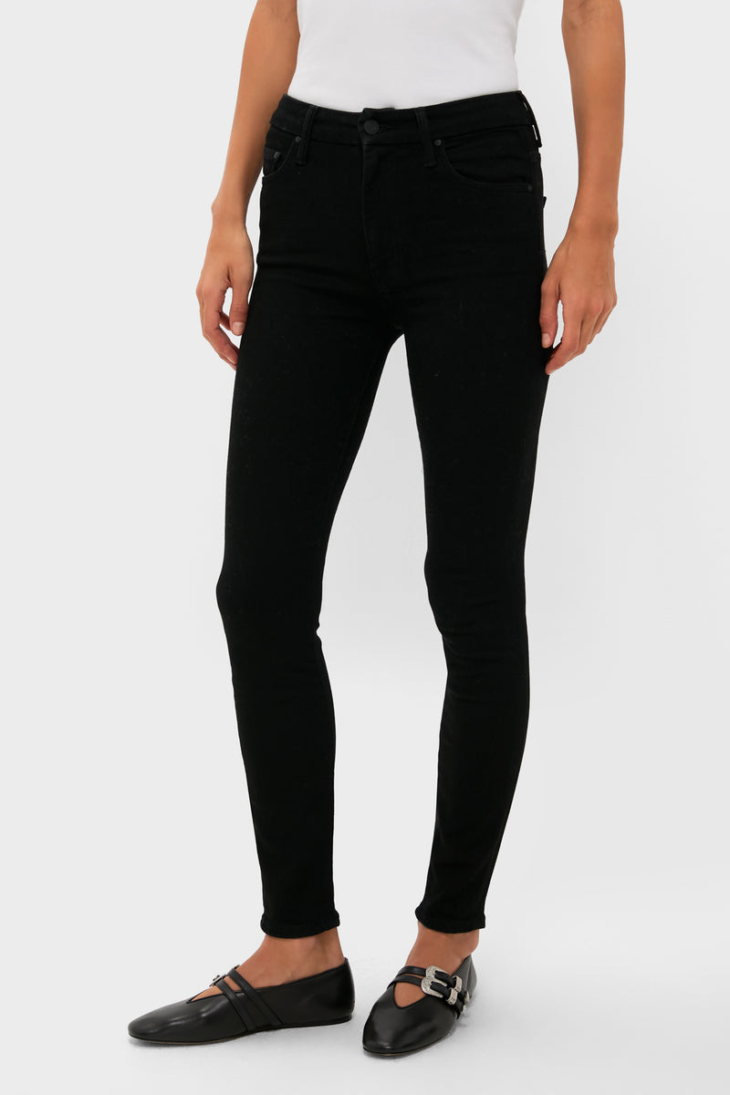 Dressed in MOTHER high-rise black skinny jeans, a white top, and black buckle flats, the person exudes a sleek, modern style.