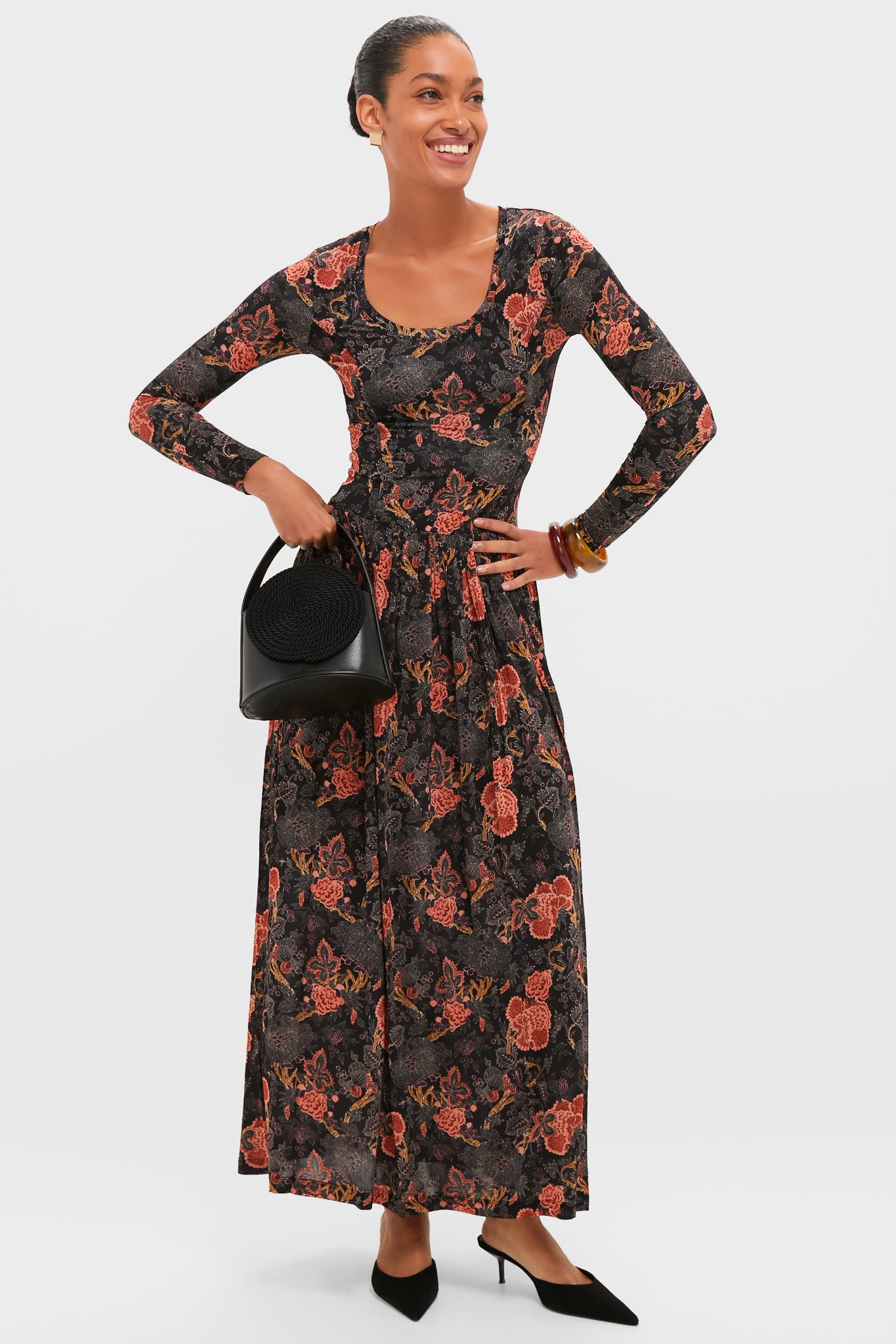 Model showcasing the Oxblood and Tortoise Rita Bangle Set, featuring chunky, classic resin bangles that add an effortless, high-end touch to her fun, elegant floral maxi dress ensemble.