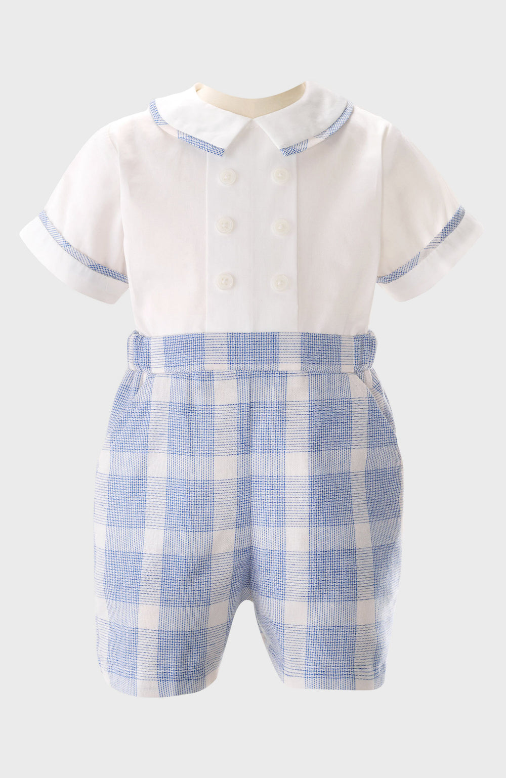 Rachel Riley infant romper inspired by British children's wear, featuring a white short-sleeve double-breasted top with blue plaid trim, matching attached shorts, and a Peter Pan collar for classic style.