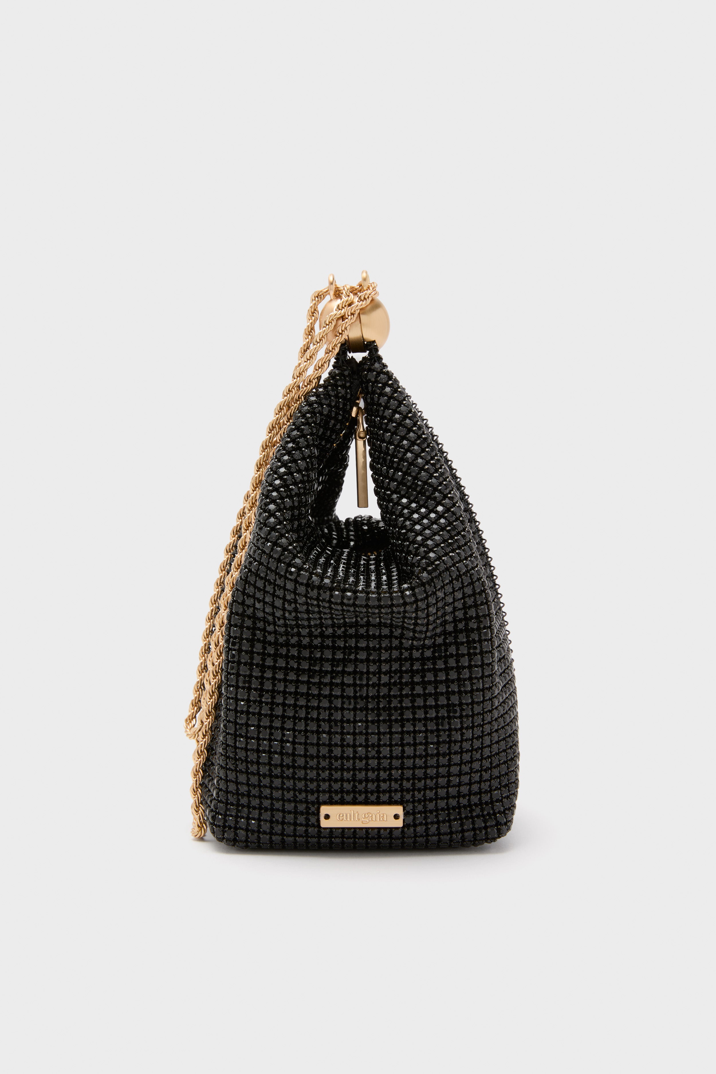 Classic and high-end, the Black Rue Wristlet by Cult Gaia features a glossy beaded mesh with a twisted gold-tone chain, exuding effortless elegance and fun.