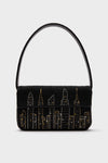 STAUD’s black Tommy Bag features hand-beaded gold and silver city skyline details and a single shoulder strap.
