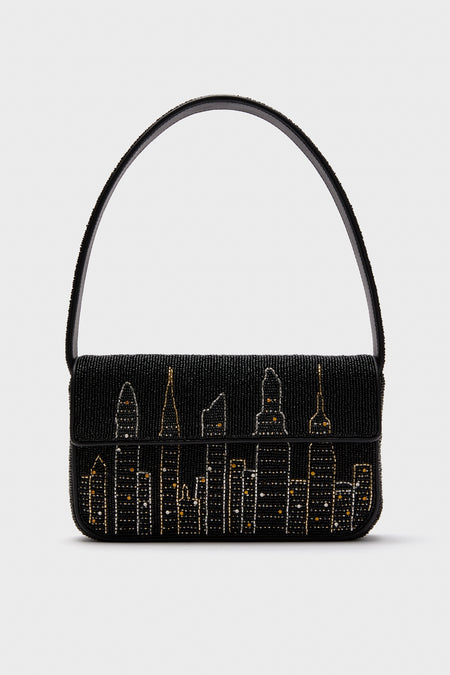 STAUD’s black Tommy Bag features hand-beaded gold and silver city skyline details and a single shoulder strap.