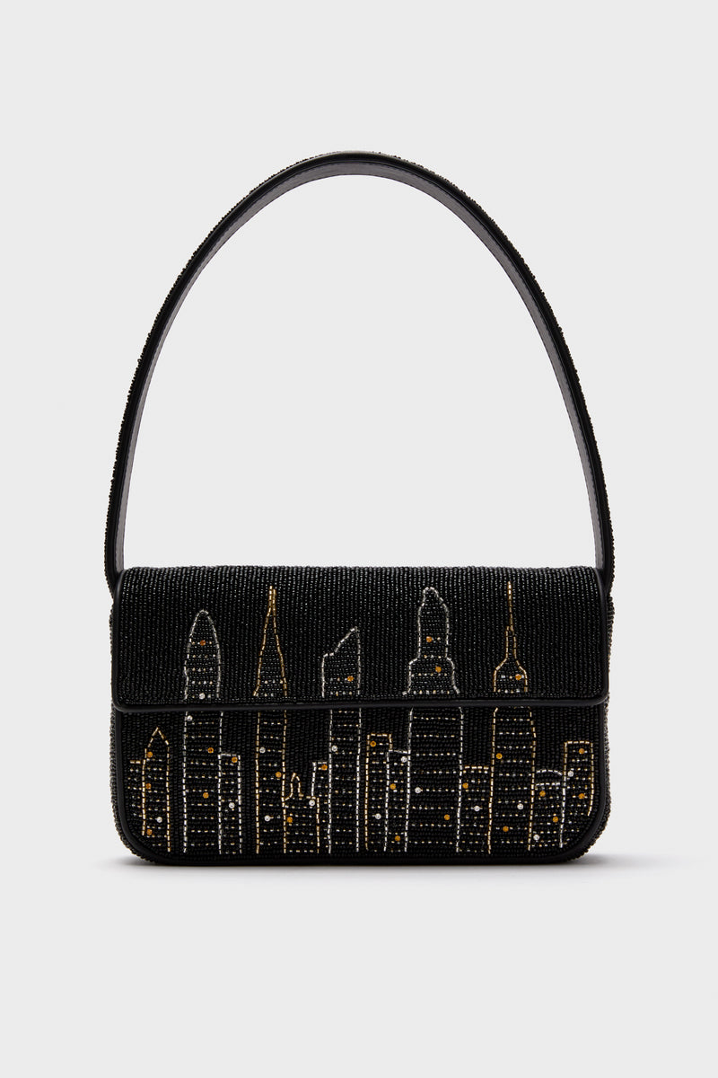STAUD’s black Tommy Bag features hand-beaded gold and silver city skyline details and a single shoulder strap.