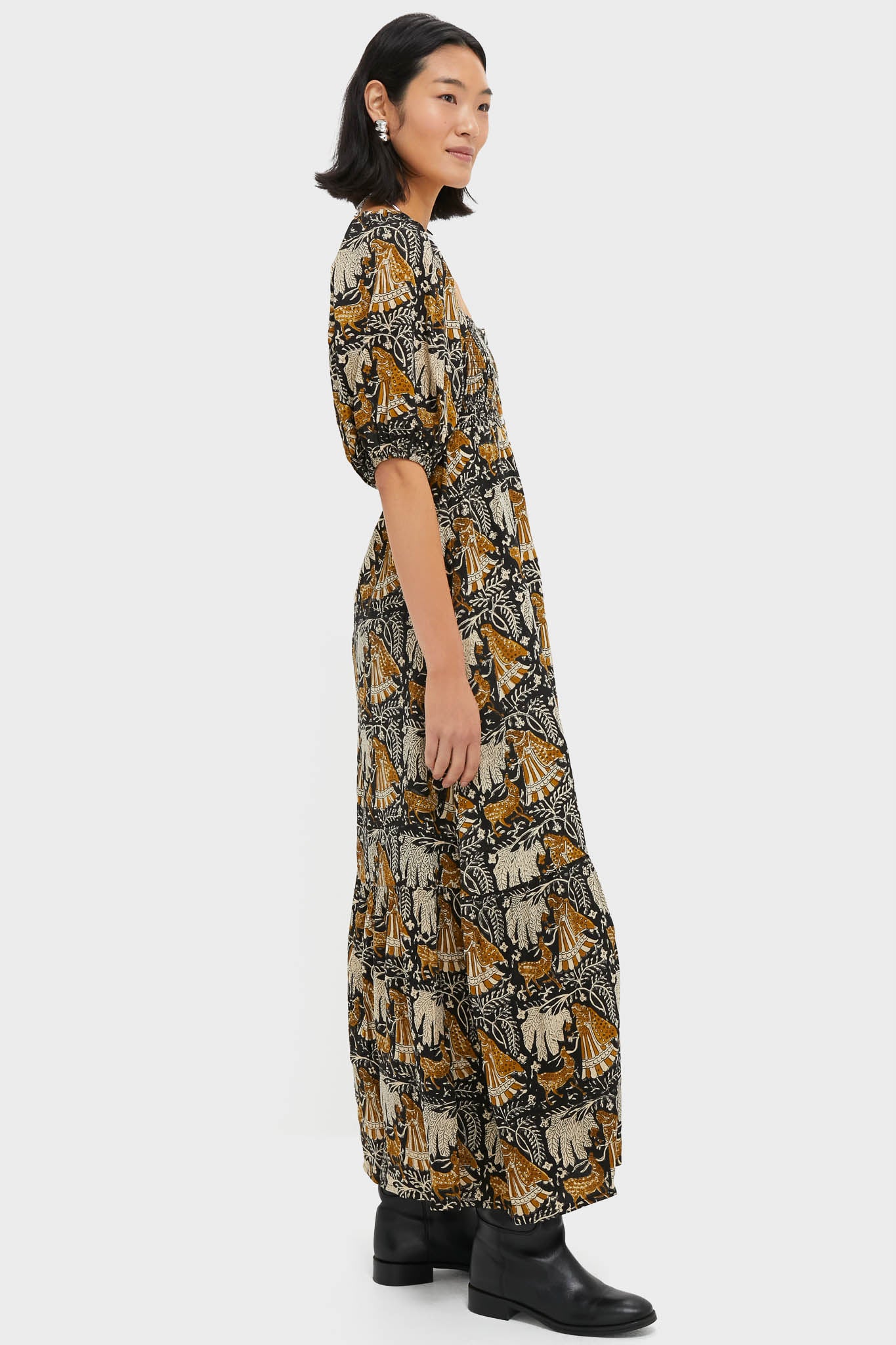 Young woman in profile wearing the Story Print Santiago 3 Maxi Dress, featuring a classic, effortless design with a smocked bodice and botanical print, styled with black ankle boots.