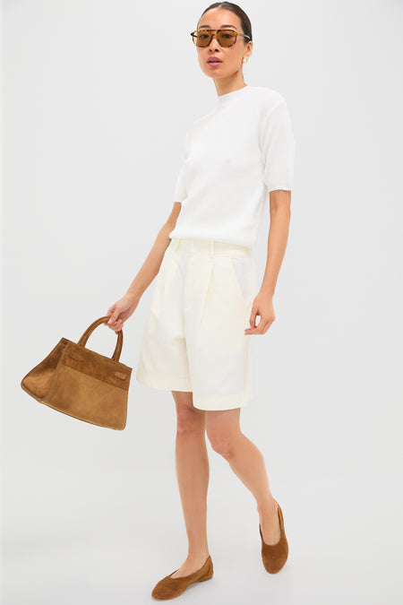 Model showcasing an effortless, high-end summer look with Gold Silver Hailey Studs, adding a classic, fun touch to her minimalist ensemble of white knit top and bermuda shorts.
