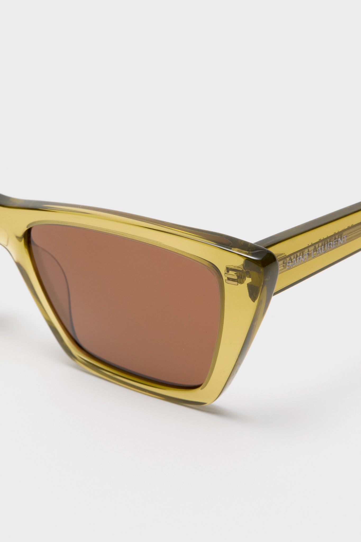 Shiny Transparent Ocra Mica Sunglasses: classic cat-eye shape with olive-green acetate frame, warm brown lenses, and SAINT LAURENT logo, offering effortless, high-end style and UV protection.