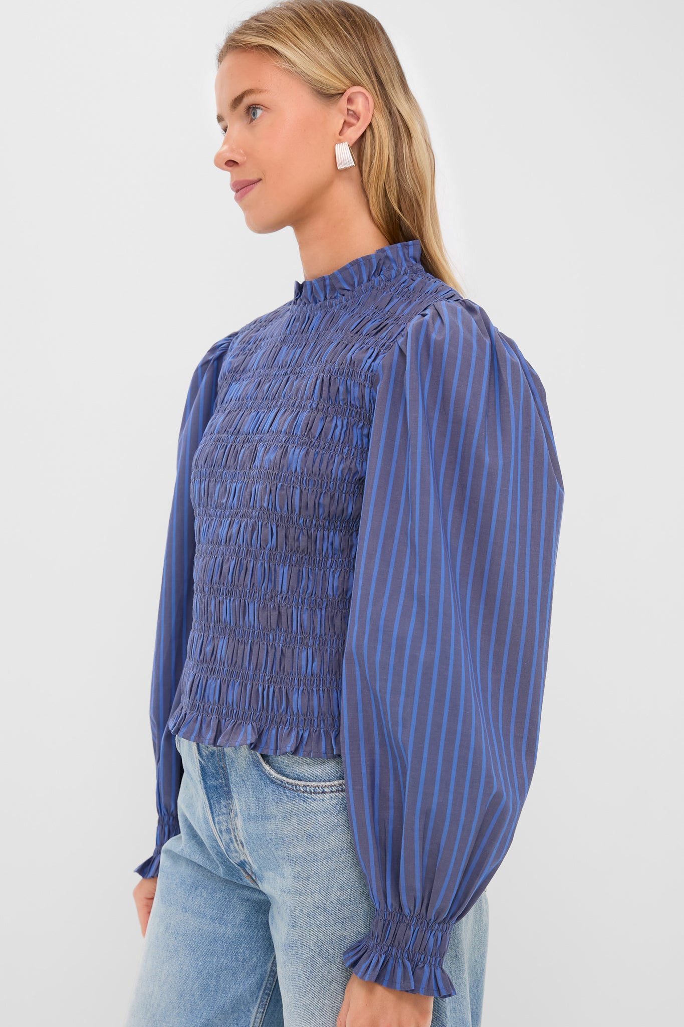 Model in classic Morgan Blue Willow Top with textured smocked bodice and full-volume sleeves, paired effortlessly with light-wash jeans for a high-end, fun look.
