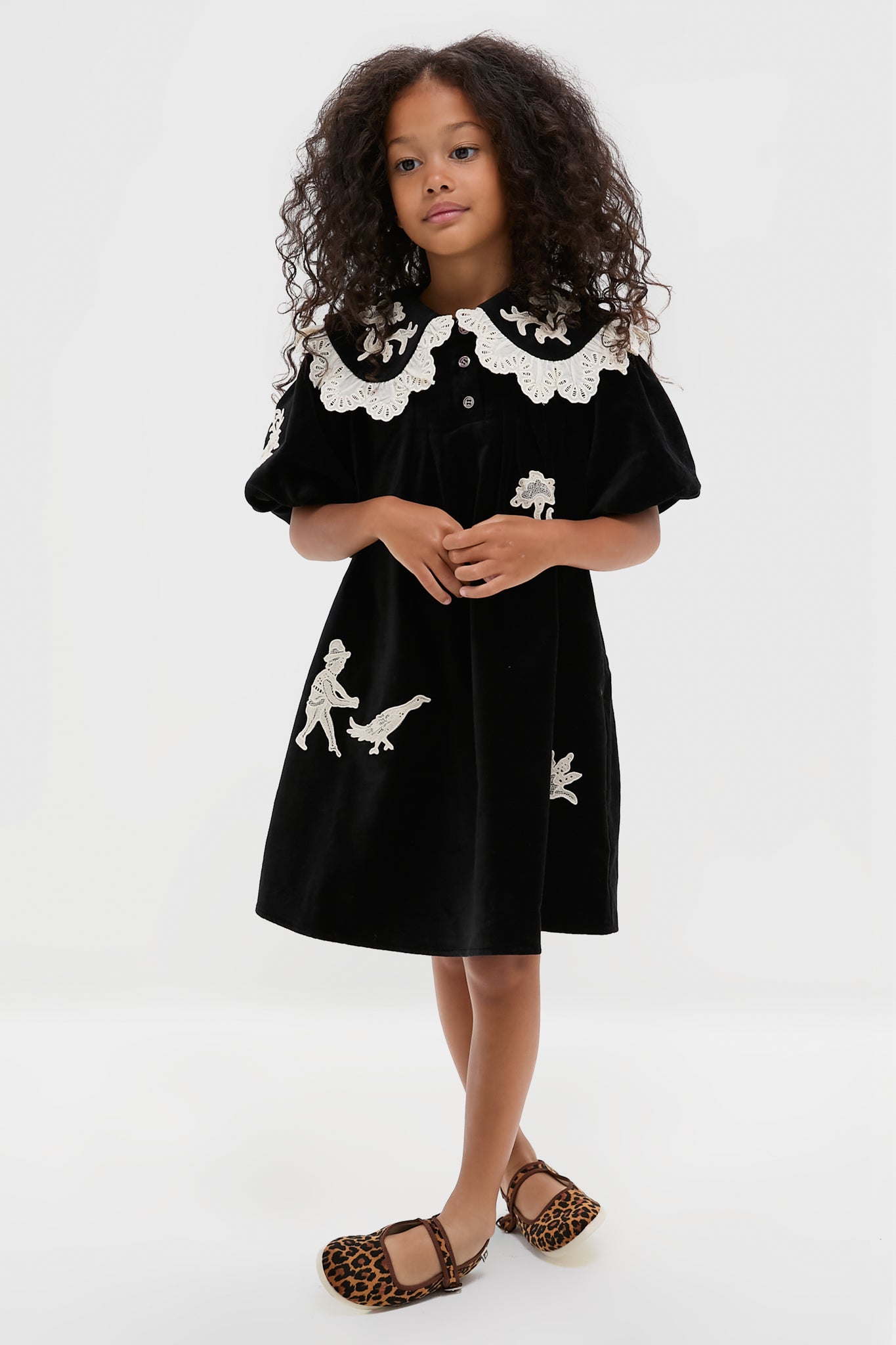 Young girl wearing classic Leopard Mary Jane Flats, effortlessly stylish with a fun, high-end touch, featuring adjustable velcro and rubber soles for adventurous steps.