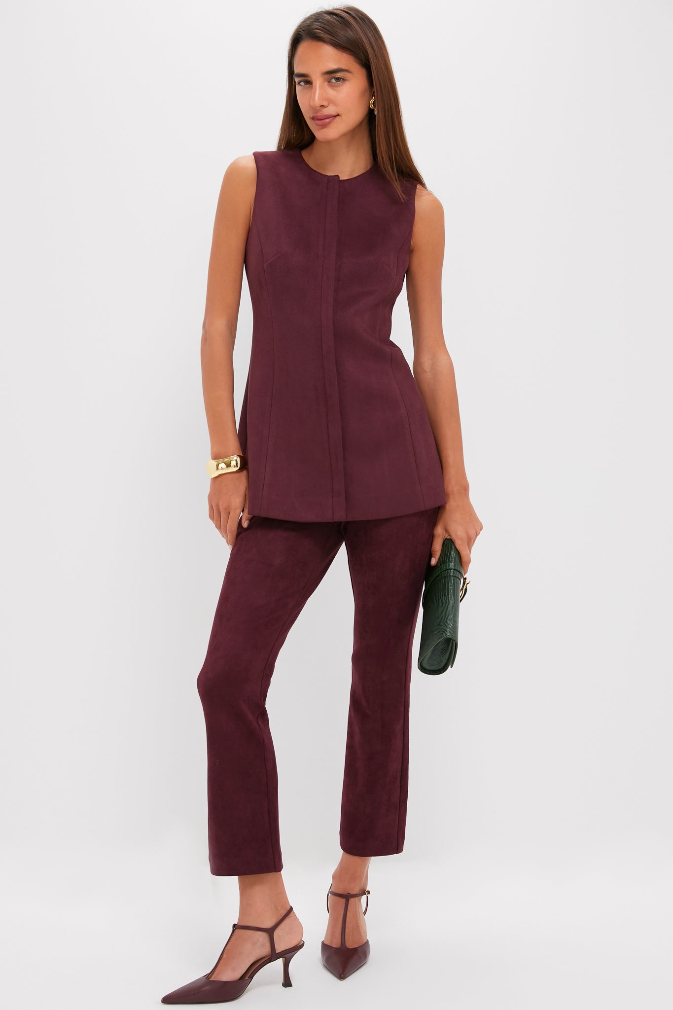 Model wearing classic Winetasting Vegan Suede Ashford Pants with a coordinated tunic, showcasing an effortless, high-end look with fun T-strap heels and a dark green clutch.