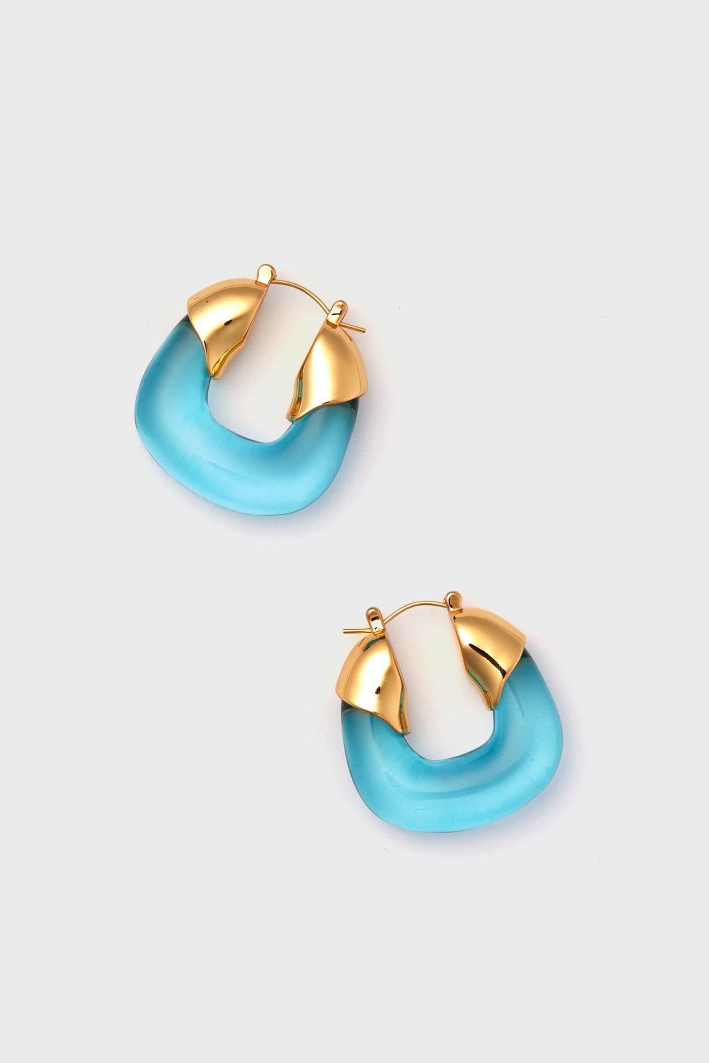 Lizzie Fortunato gold-plated brass earrings featuring translucent blue curved bases and geometric acrylic accents for a stylish, modern look.