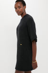 A woman in a GANNI relaxed fit knit t-shirt dress stands sideways against a plain background, her expression neutral.