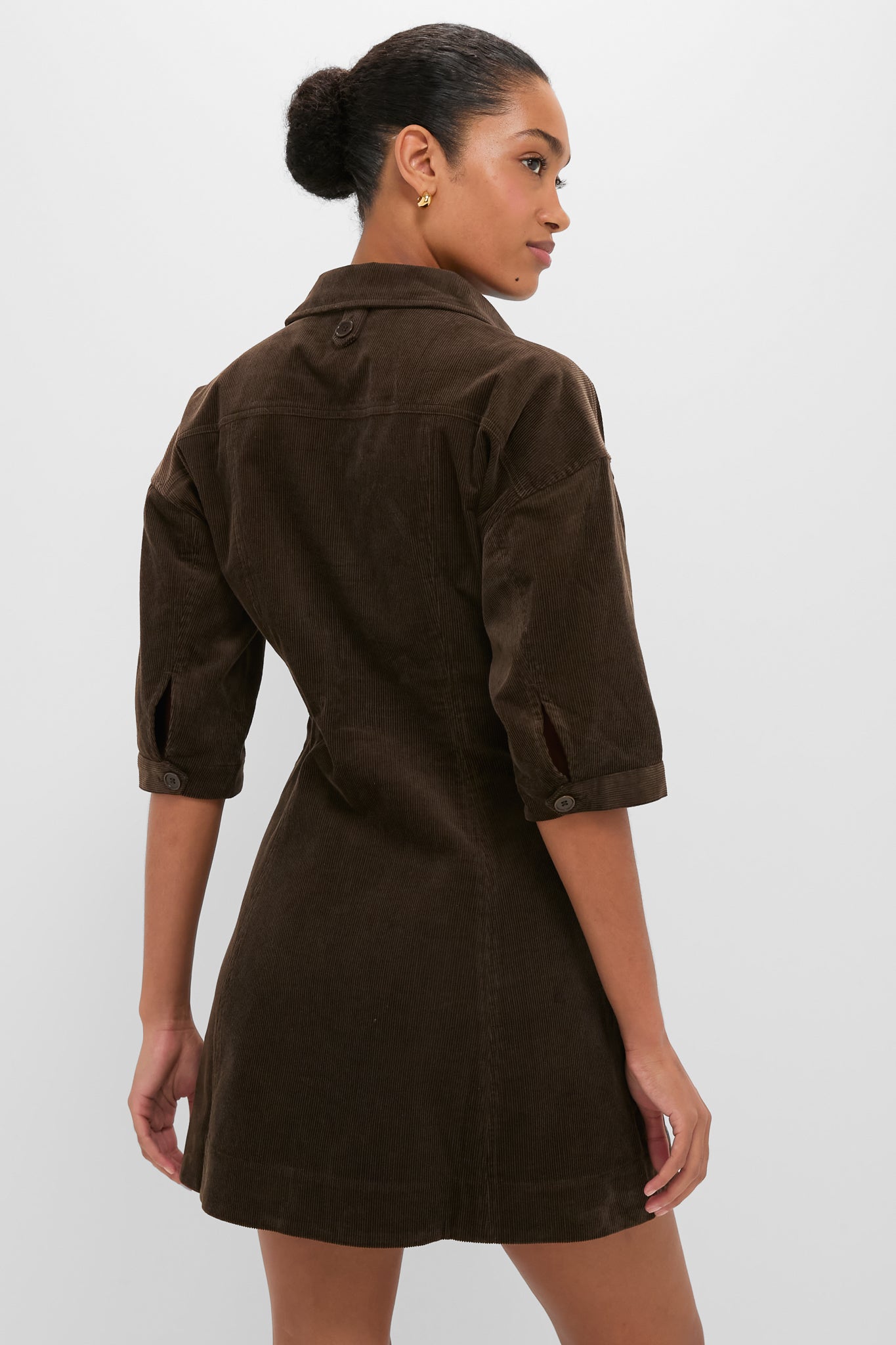 Back view of a model in the Carob Luz Mini Dress, highlighting its classic, effortless style with a flared skirt and fitted waist. Perfect for a high-end, fun look.