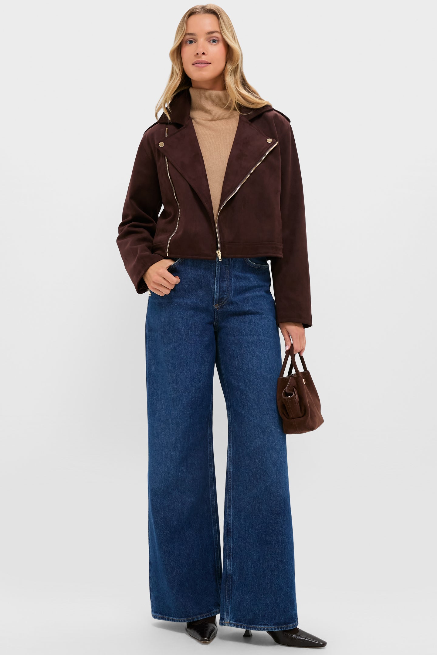 Model wears Chocolate Faux Suede Bristol Jacket with an asymmetrical zip, styled over a camel turtleneck and high-waisted jeans, exuding an effortless, classic, high-end appeal.