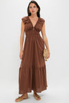Woman models the classic Chestnut Brown Hedda Maxi Dress, featuring a deep V-neckline, ruched waist, tiered skirt, styled effortlessly with gold jewelry and sandals.