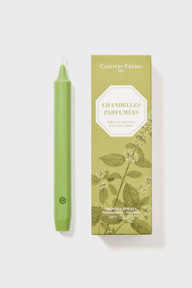 A green vegetable wax taper candle by Carrière Frères, spearmint scented, sits next to a rectangular "Chandelles Parfumées" box adorned with botanical illustrations.
