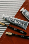 Soft Tortoise Natural Bristle Toothbrush with classic dark handle and light bristles, exuding effortless style, paired with Marvis Whitening Mint toothpaste, creating a fun, high-end oral care set.
