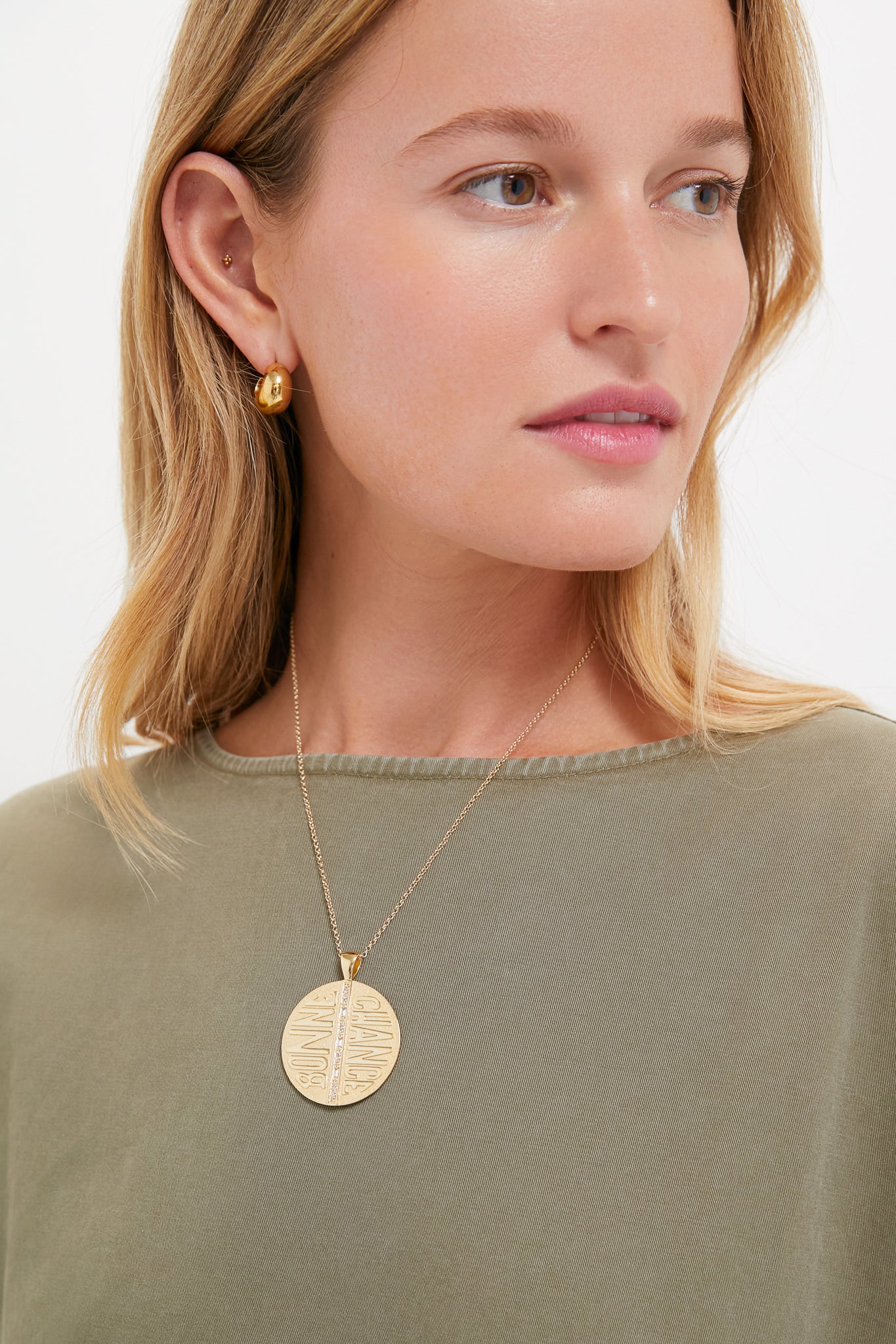 Woman wearing the Gold Jumbo Bonne Chance Coin Necklace, a classic and effortless 14k gold-plated pendant with BONNE CHANCE inscription, exuding fun, high-end style.