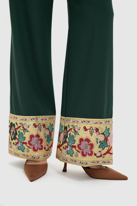 Model showcases Garden Scrollwork Jacquard Cuff Erin Pants, featuring classic wide-leg design with elegant floral jacquard trim, paired effortlessly with brown mules for a high-end look.