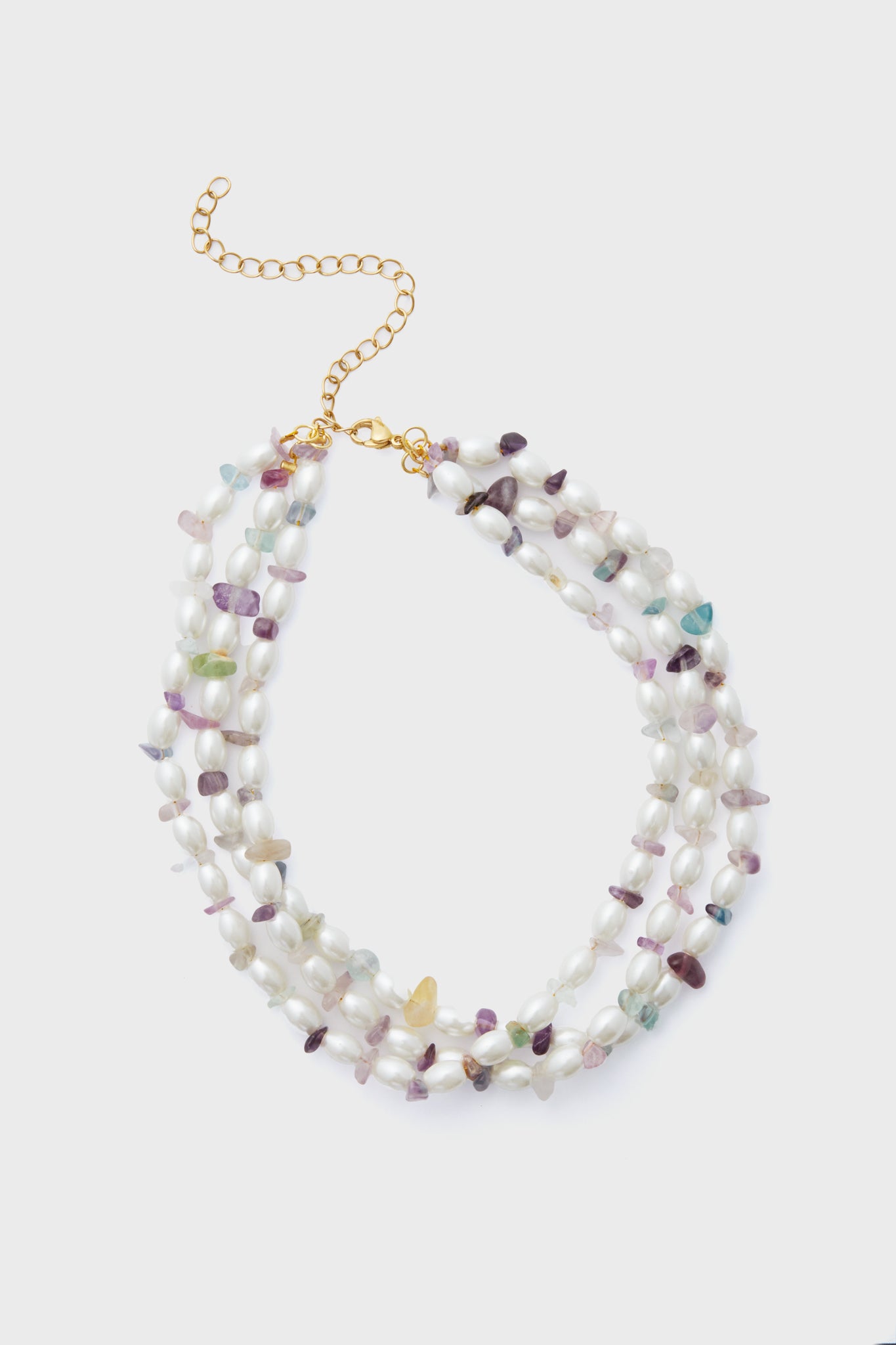 The Petit Moments three-strand choker features irregular white pearls, multicolored gemstone beads, and a gold chain with clasp—an elegant accessory for any occasion.