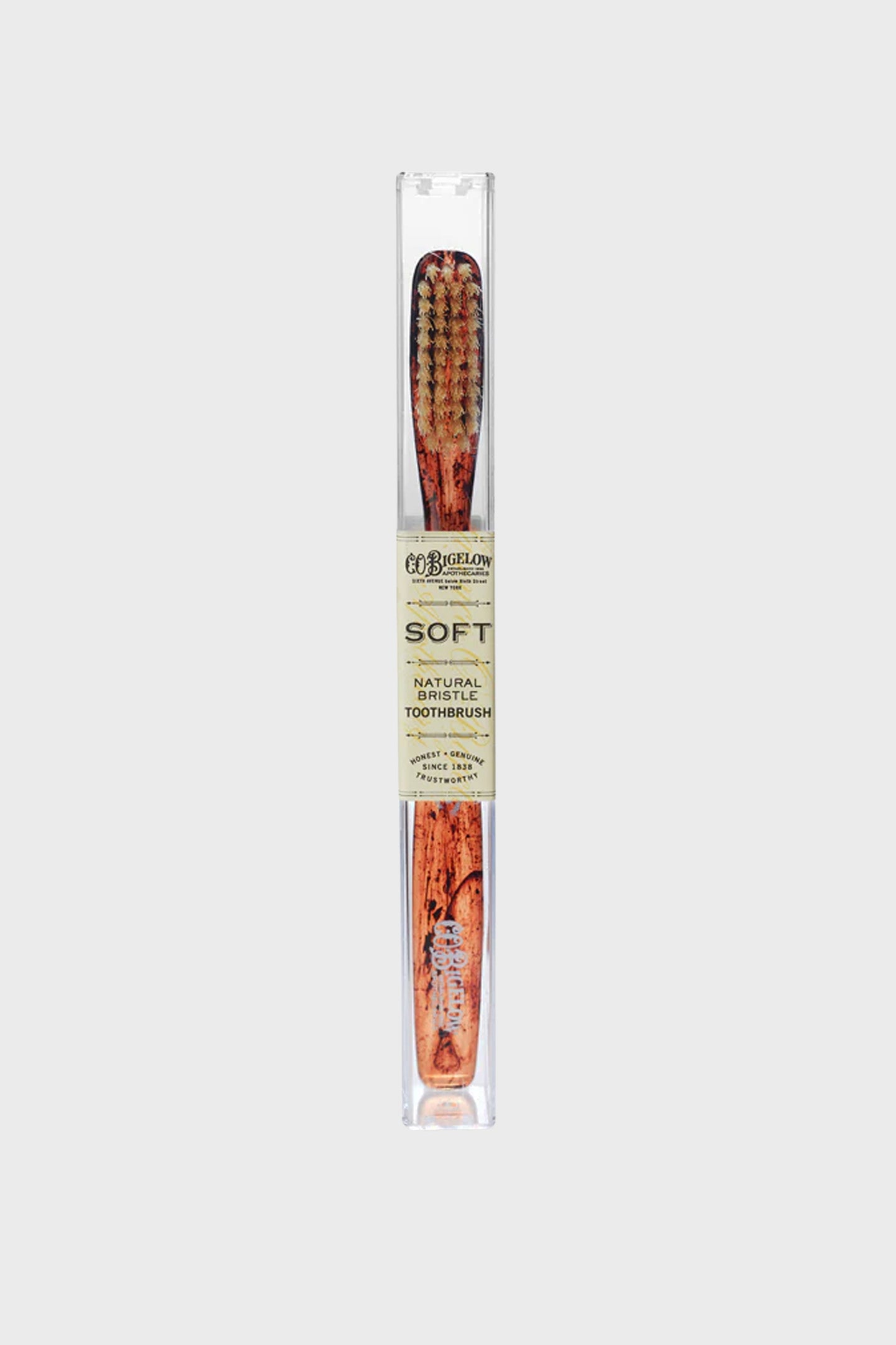 Soft Tortoise Natural Bristle Toothbrush by C.O. Bigelow, featuring classic wood-grain handle, effortless design, and high-end natural bristles in a clear travel sleeve.