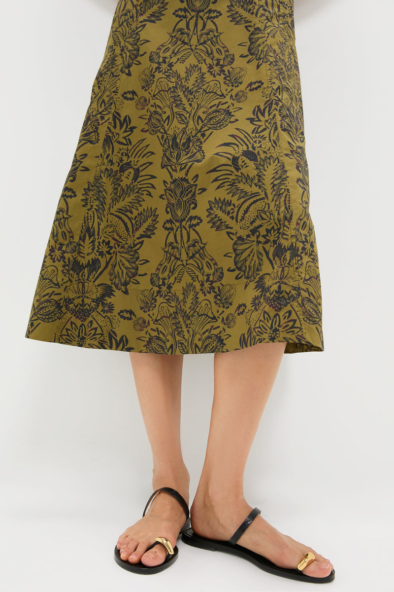 Olive Flora Natali Dress: A classic, high-end calf-length skirt with an effortless olive-green and black floral pattern, paired with minimalist black sandals featuring a fun gold buckle.