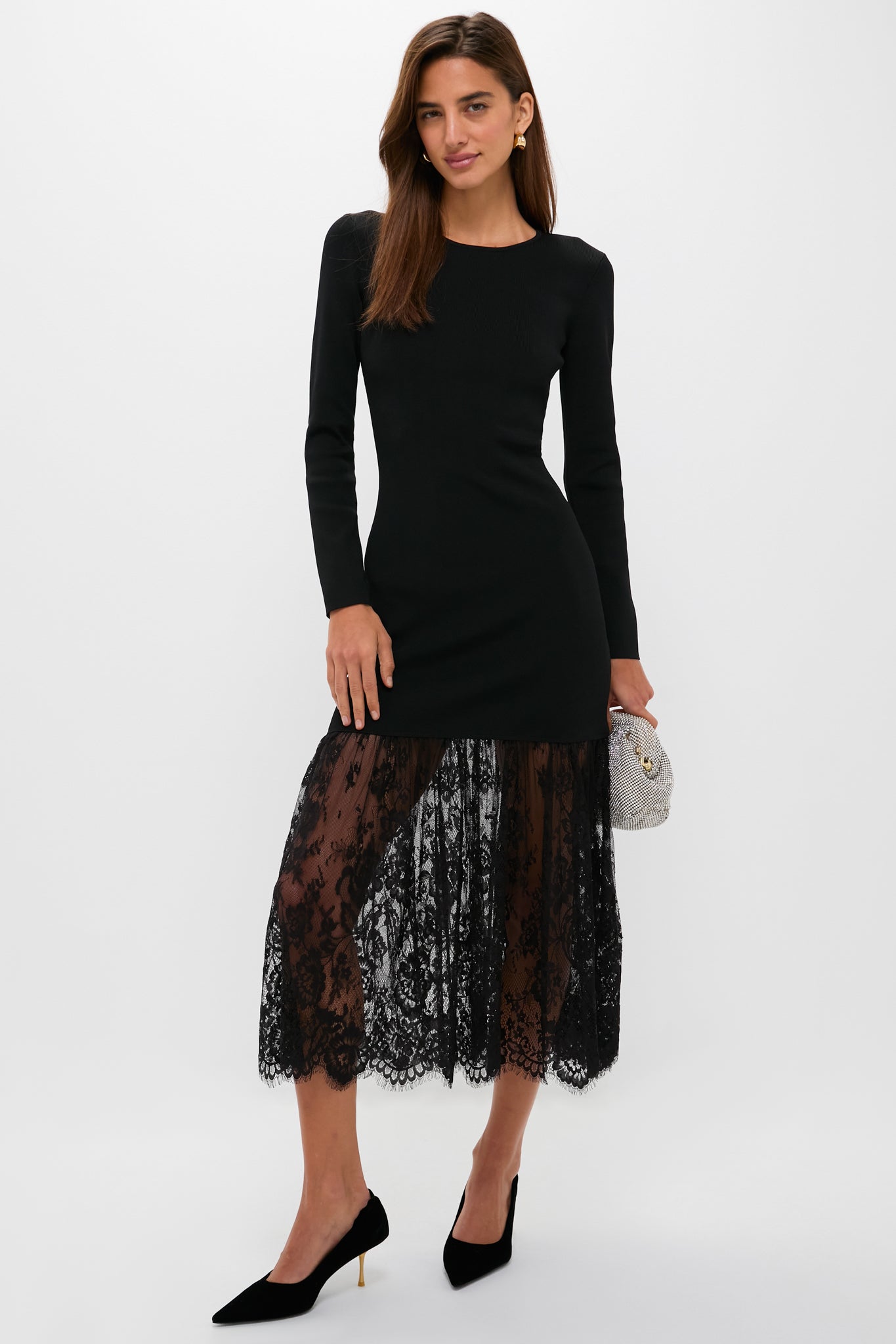 Woman in Black Knit Giavanna Maxi Dress, featuring a classic fitted bodice, sheer lace skirt, and gold-accented heels, exuding effortless, high-end evening glamour.
