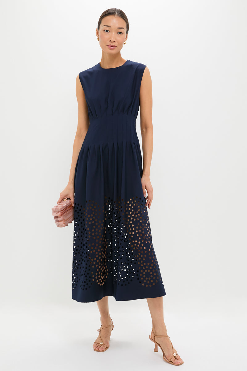 Navy Astrid Midi Dress: A classic, sleeveless navy dress with a fitted waist and full skirt featuring a fun, high-end laser-cut polka-dot pattern, embodying effortless style.