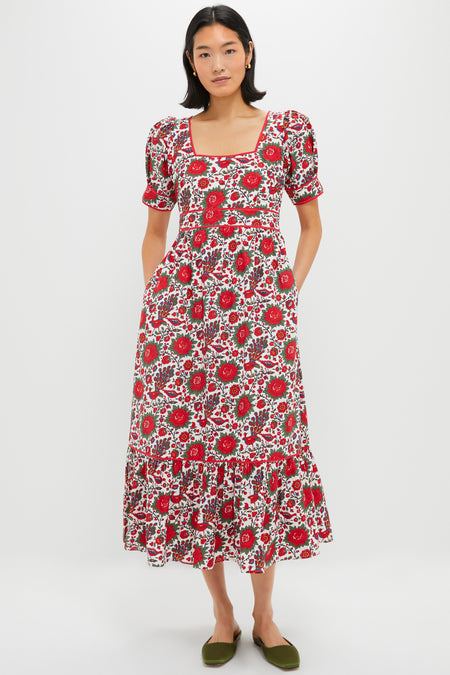 A woman wears a Pink City Prints red floral cotton poplin dress with short puff sleeves and a square neckline, paired with green flats.