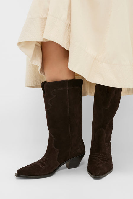 Dark Espresso Suede Wilson Cowboy Boots add effortless western charm, featuring classic pointed toes and decorative stitching, paired stylishly with a light skirt for a fun, high-end look.