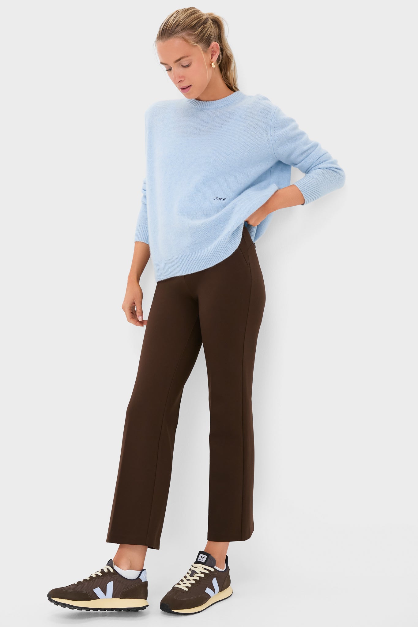 Woman wearing Chocolate Brown 28 Inch Compression September Pant, paired with a light-blue knit sweater, embodying a classic, effortless, high-end style for versatile, fun everyday wear.