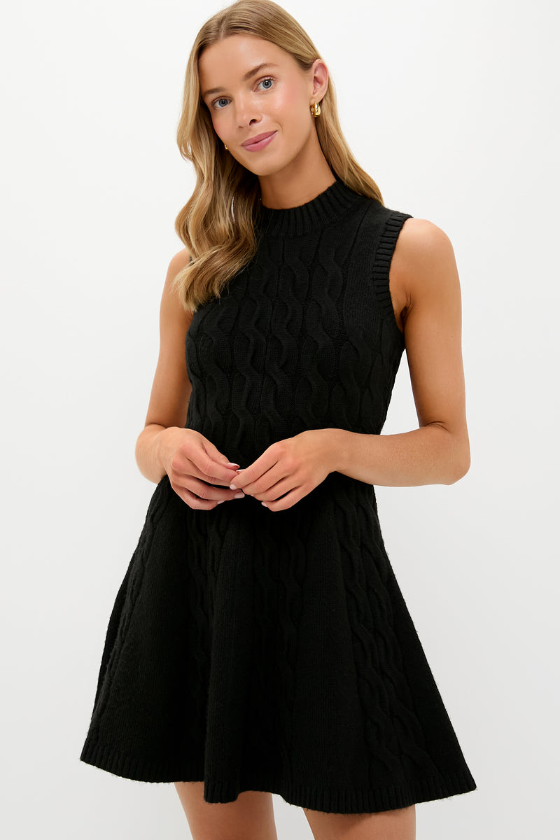 A woman wears a Hyacinth House sleeveless black cable knit mini dress featuring a flared skirt and ribbed knit details.