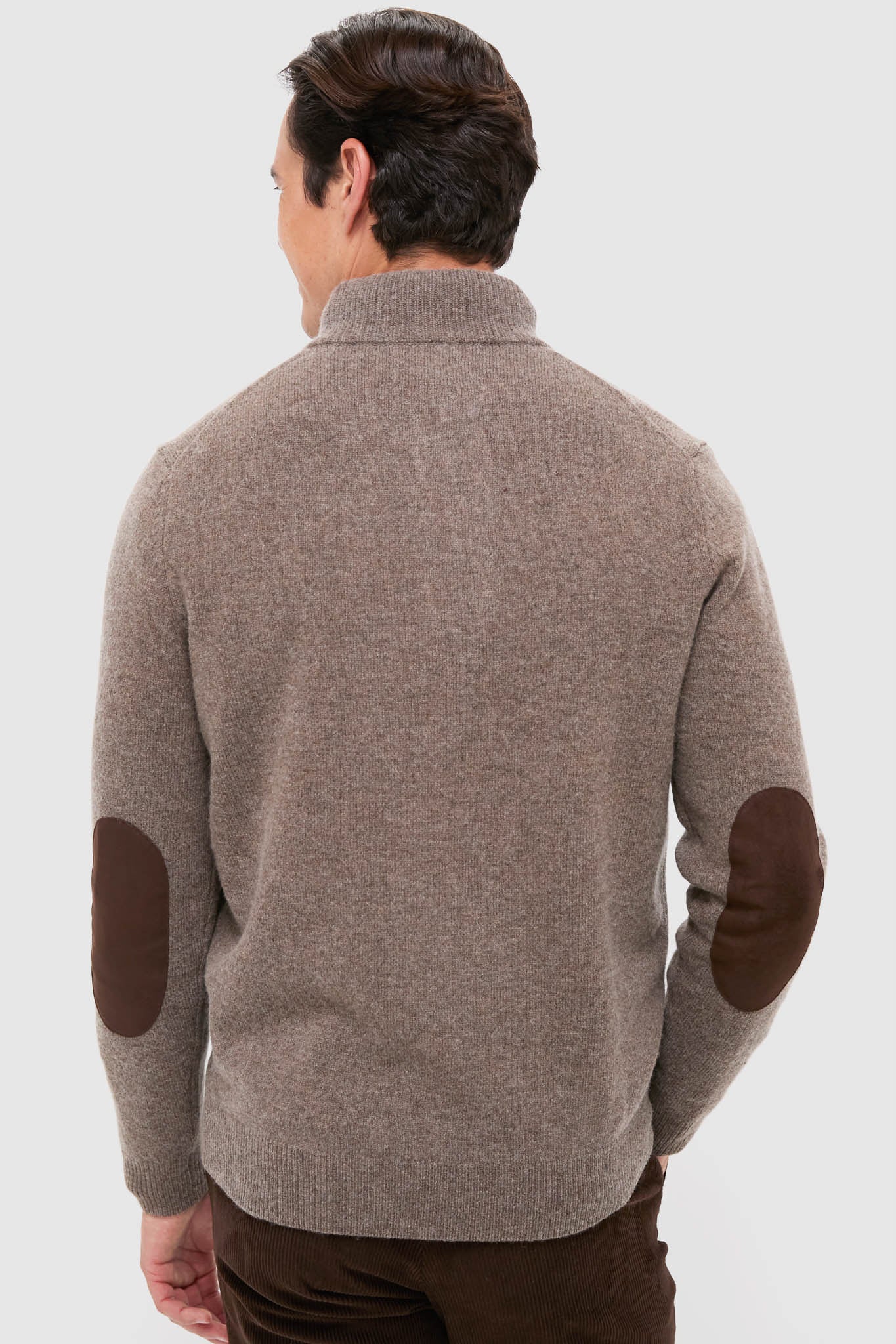 Man in classic Dark Stone Essential Patch Half Zip Knitted Jumper with leather elbow patches, showcasing an effortless style. Perfect for a fun, high-end, cozy look.