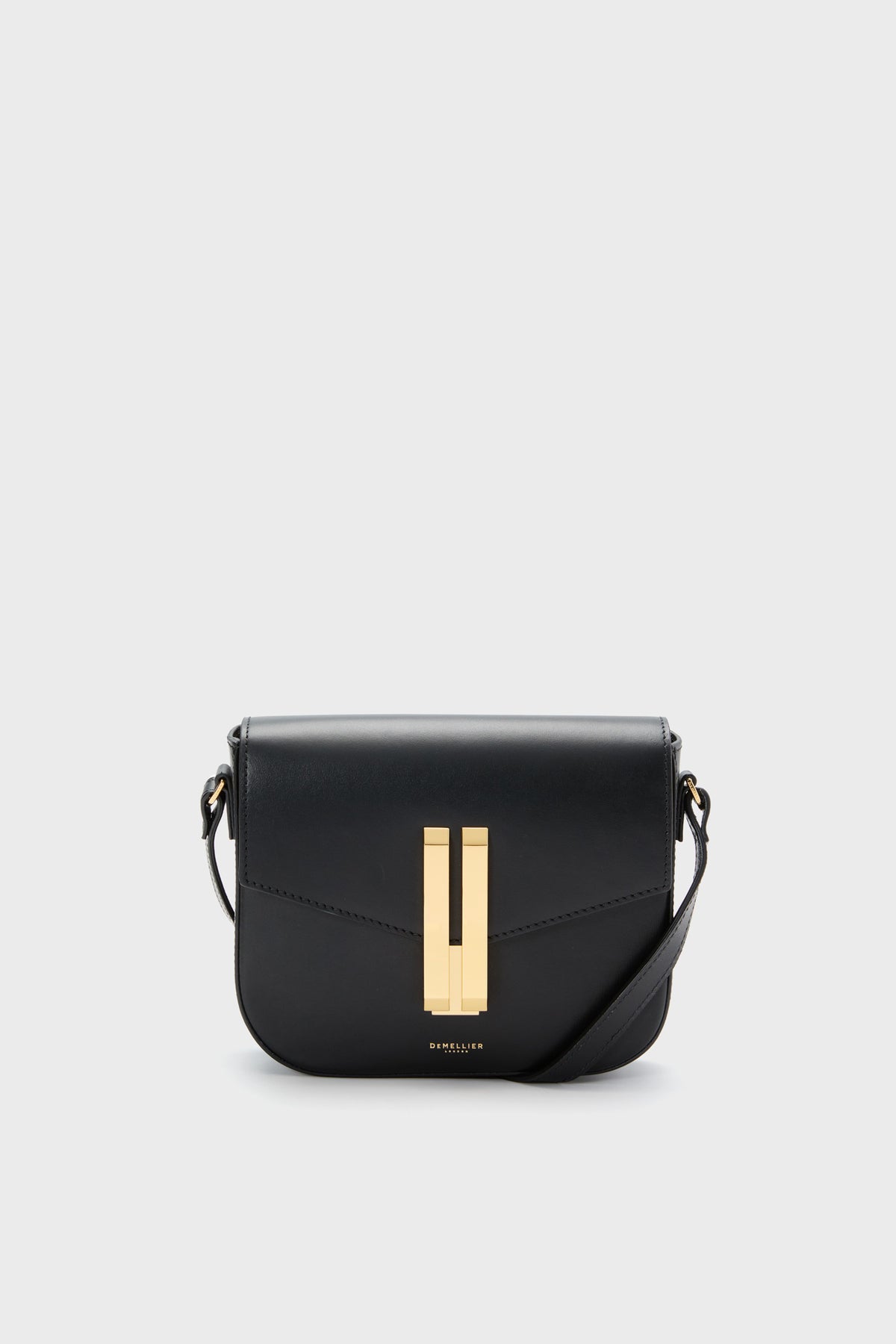 The Demellier Black Small Vancouver Bag is a black leather crossbody with gold hardware and a front flap, blending elegance and functionality in a compact design.