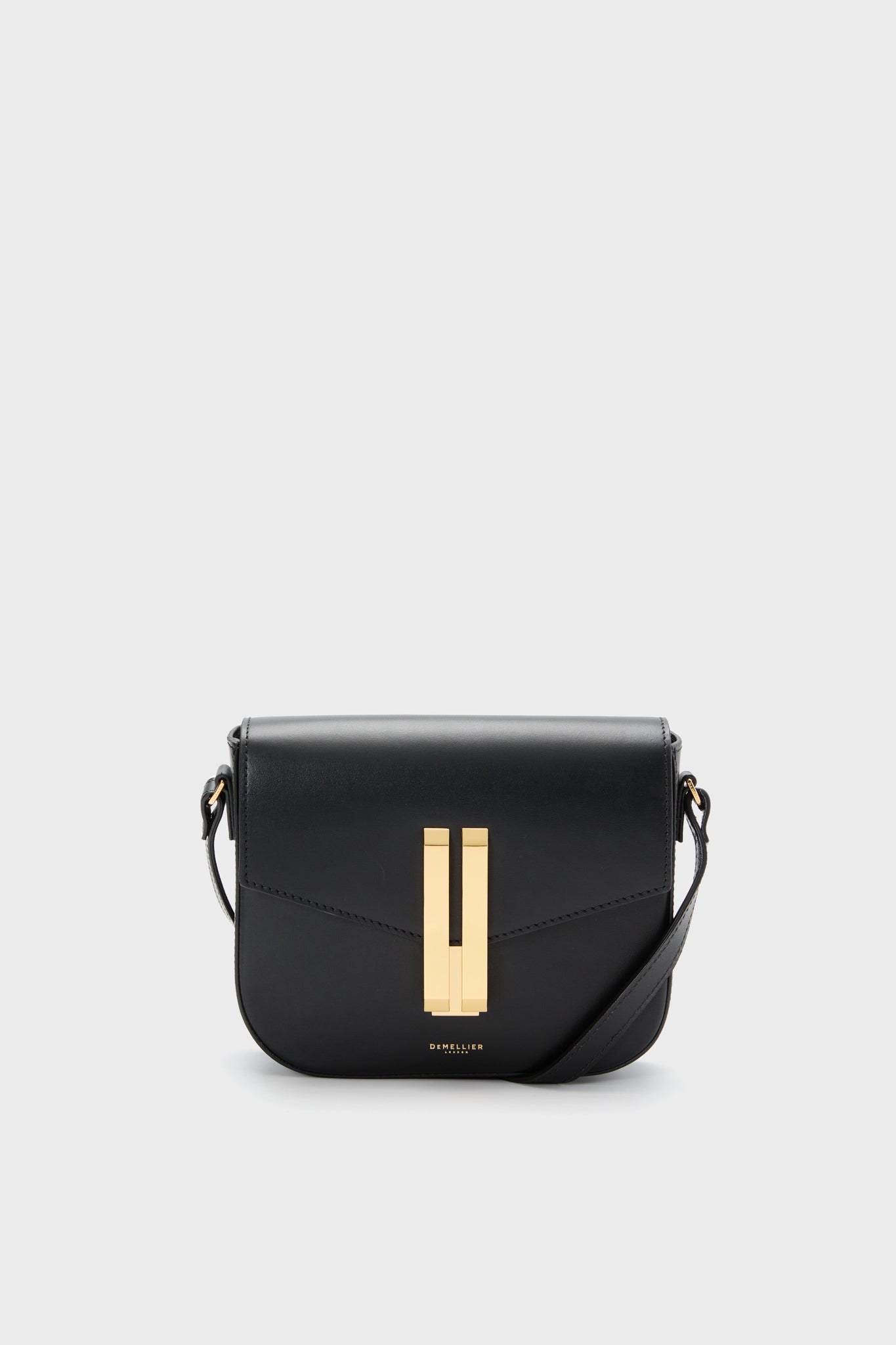The Demellier Black Small Vancouver Bag is a black leather crossbody with gold hardware and a front flap, blending elegance and functionality in a compact design.