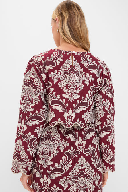 Woman in Blush Pink and Burgundy Bicolor Jacquard Waves Long Sleeve Top, featuring classic baroque patterns and scalloped hem, embodies effortless, high-end style for fun, sophisticated occasions.