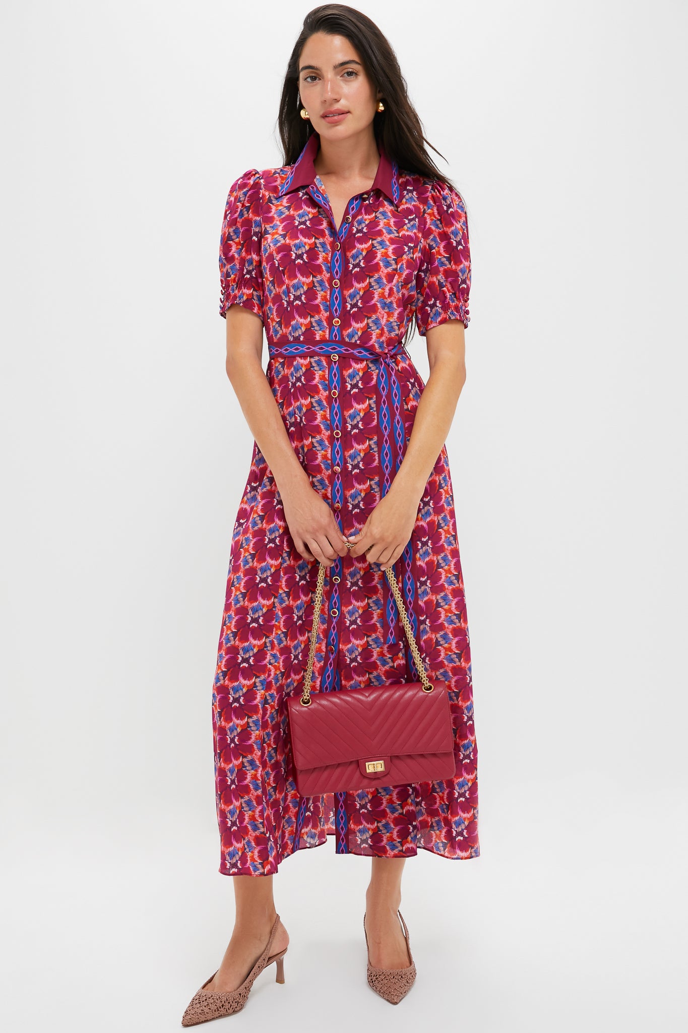 Model wearing the Quail Magenta Vanessa-D Midi Dress, featuring a classic floral pattern, effortless A-line silhouette, and fun puff sleeves, paired with a high-end quilted red bag.