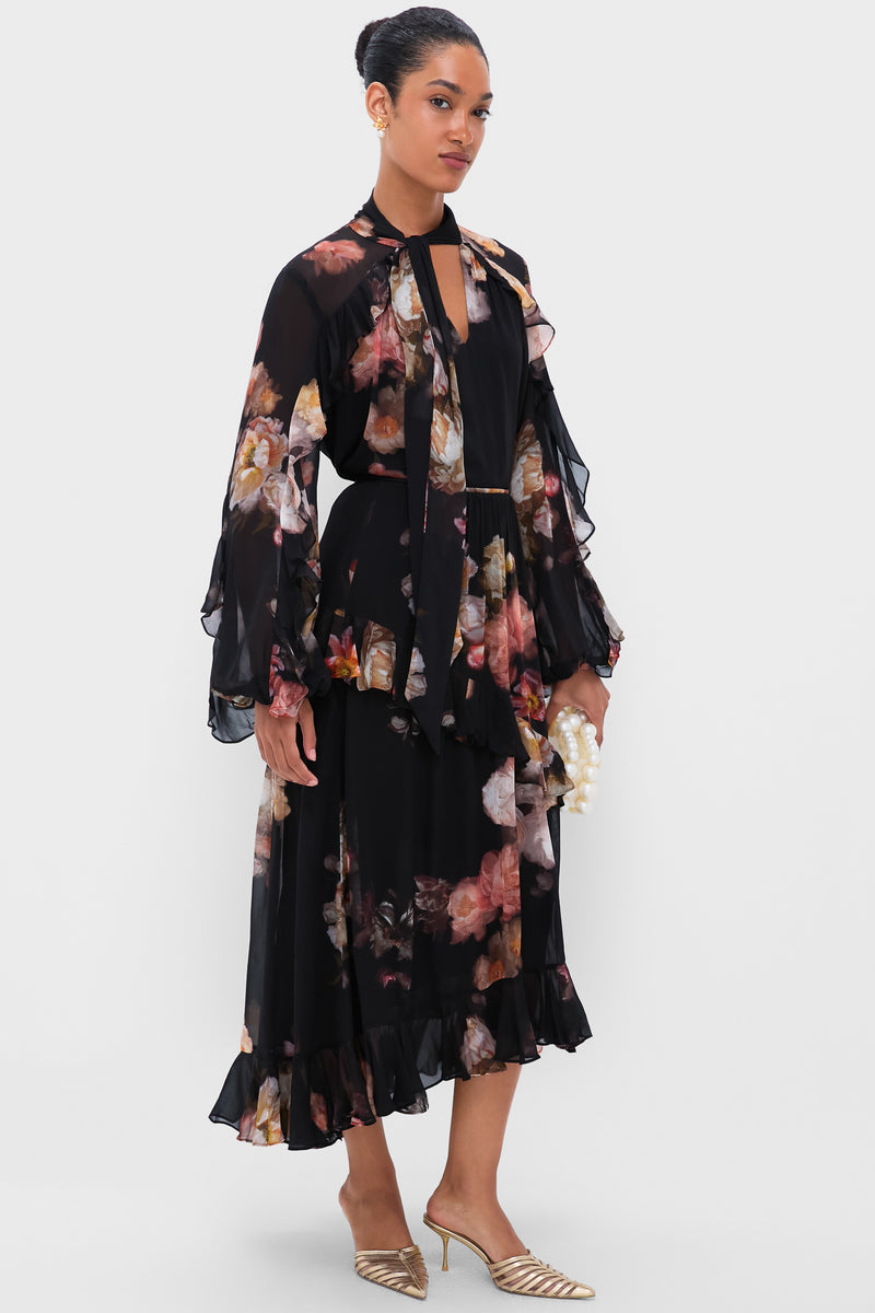 Model in a classic, floral chiffon dress, showcasing Gold Rici Earrings with pearl drops, embodying effortless sophistication and fun, high-end style.