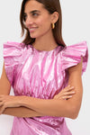 Woman in a Pink Plisse Coolidge Mini Dress with ruffled sleeves and a chunky gold hoop earring, embodying classic, effortless style for a fun and high-end look.