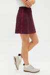 Winetasting 16 Inch Performance Stretch Woven Karrie Golf Skirt, featuring a classic A-line design with vertical stripes, paired with white socks and cream perforated oxfords. Effortless and fun style.