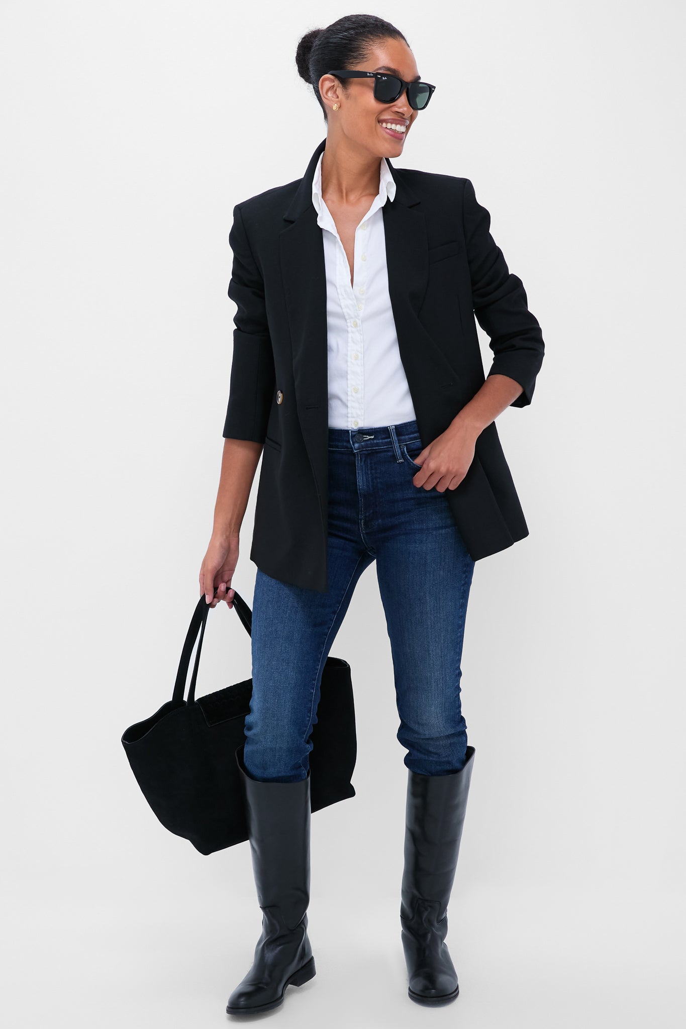 Woman in classic, effortless outfit featuring You're A Riot The Rascal Skimp jeans, styled with a blazer and boots, exuding fun and high-end confidence.