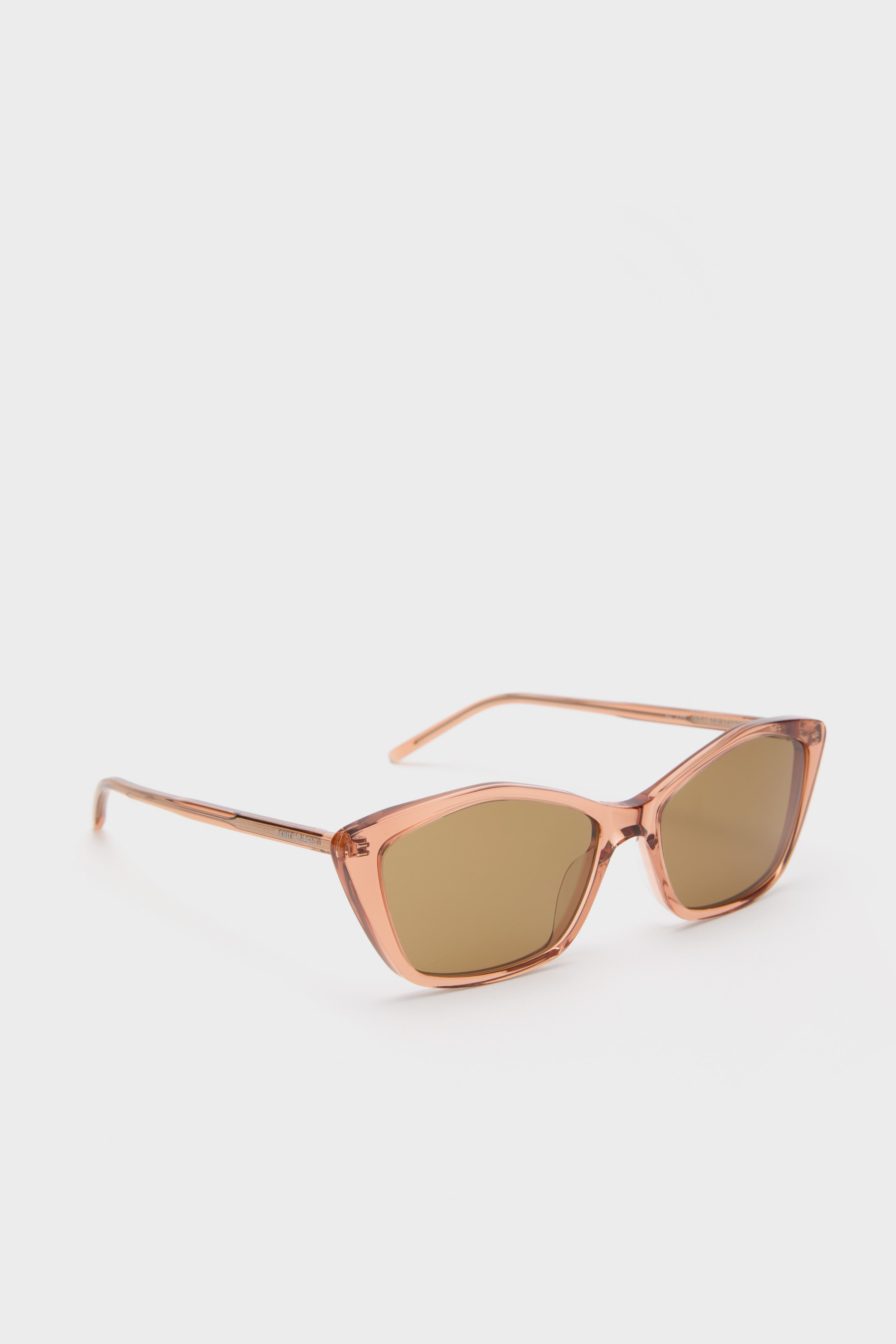 Classic cat-eye sunglasses with a shiny transparent amber-brown thin frame and brown lenses, featuring a subtle logo. Effortlessly high-end and fun accessory.